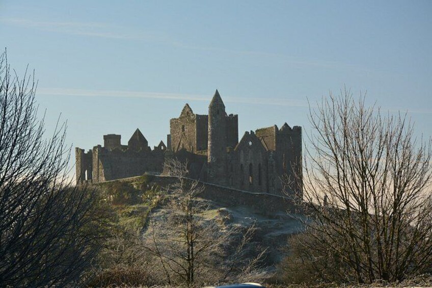 A medieval castle with multiple towers and walls, surrounded by bare trees and a clear sky. 4