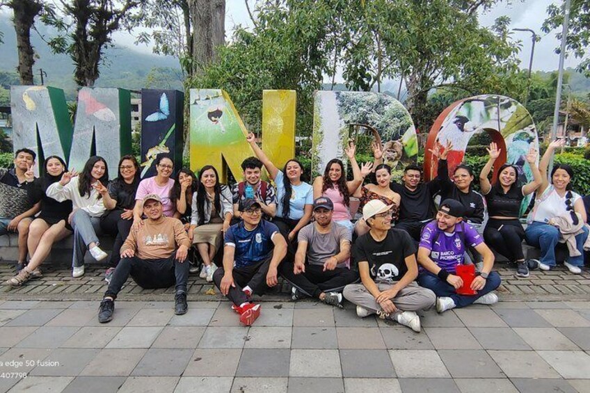 A group of people posing in front of colorful, large letters spelling 'MELDOR.' 4