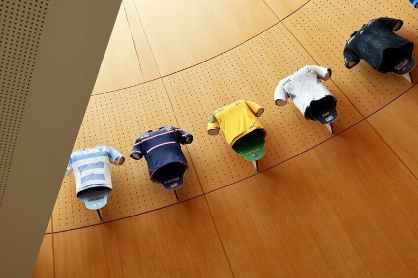 A row of baby clothes hanging on a wooden wall. 3