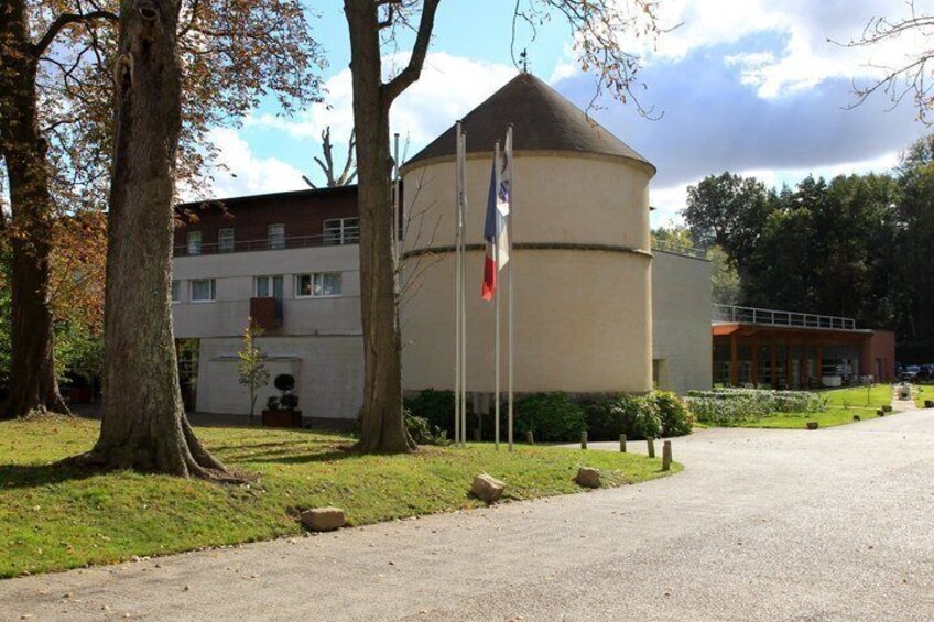 A building with a round tower, flags, and a paved road. 2