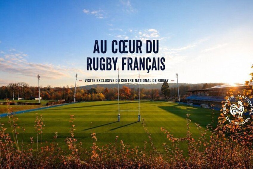 A rugby field with a stadium in the background, under a clear sky. 1