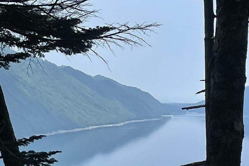 A calm body of water surrounded by forested hills. 2