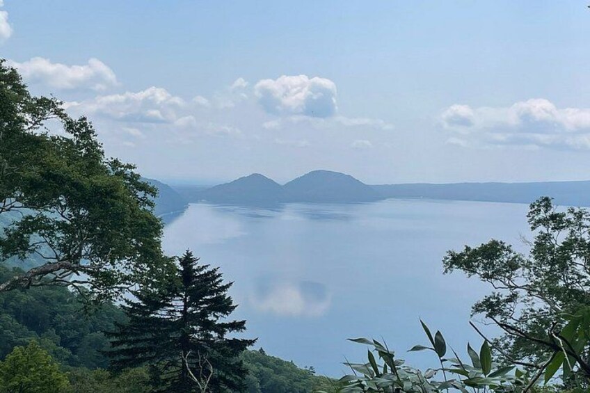 A calm lake surrounded by mountains and trees. 4