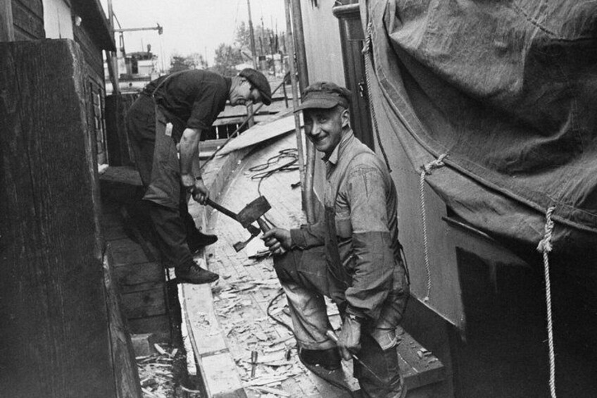 Two men working with tools in an outdoor setting, possibly a construction site. 3