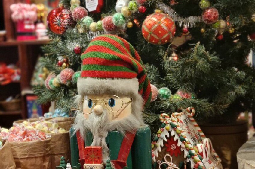 A Christmas tree with ornaments and a Santa Claus figurine in front of it. 4