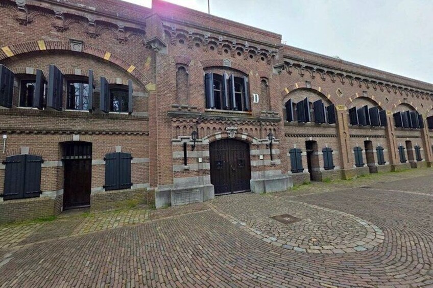 A historic brick building with arched windows and a cobblestone courtyard. 5