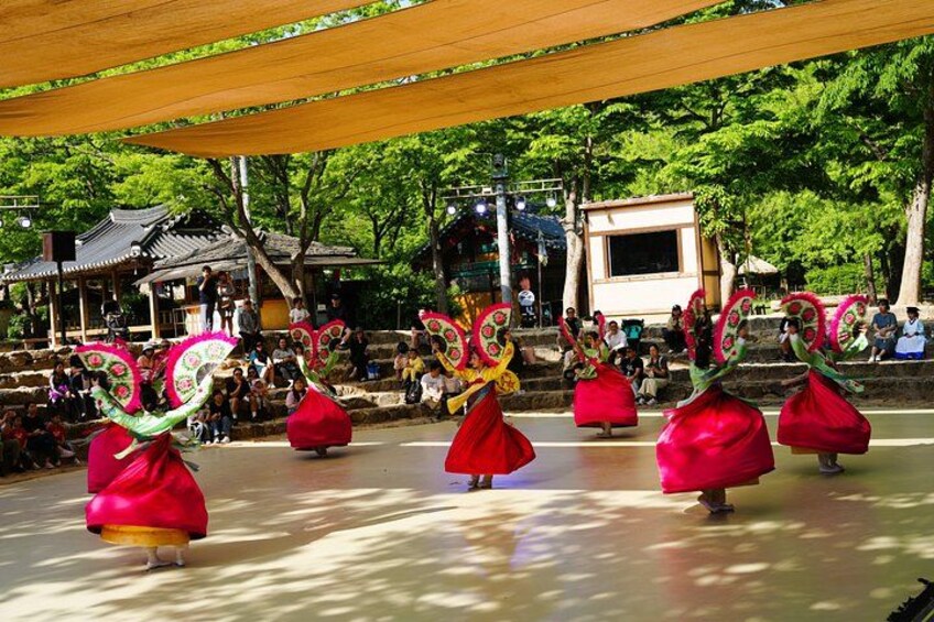 A traditional dance performance with performers in red costumes and elaborate headpieces. 2