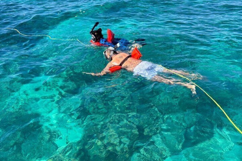 Two people snorkeling in clear blue water. 3