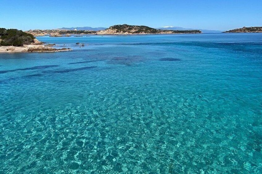 A clear blue sea with sandy beaches and rocky outcrops. 2