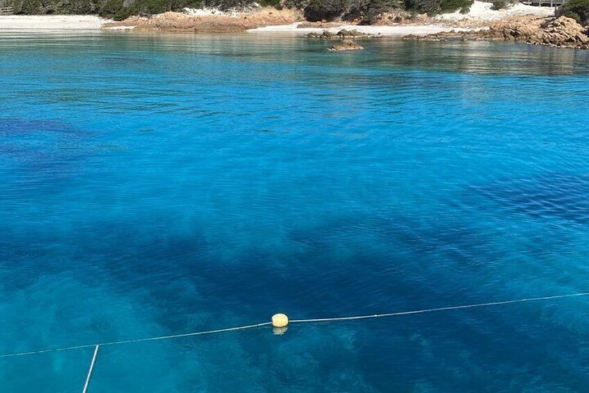 A clear blue sea with a buoy and a boat's rope. 4