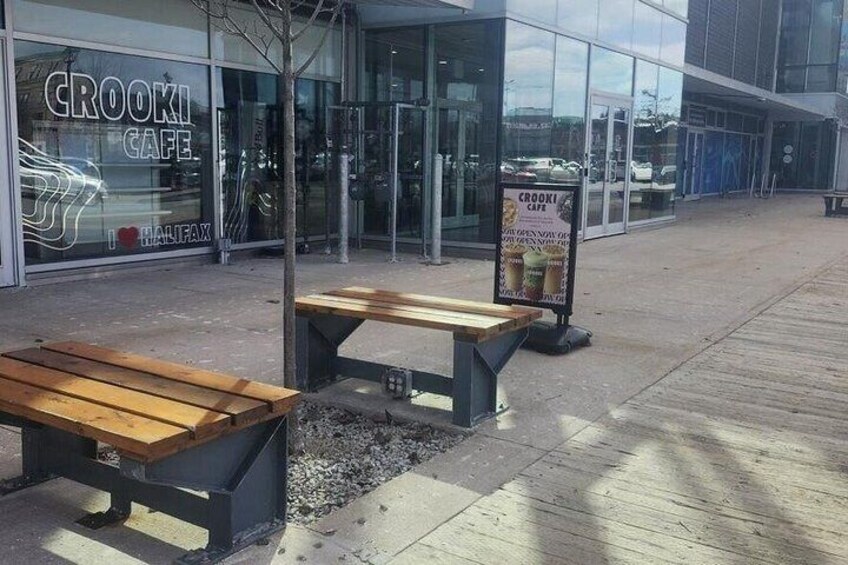 A cafe named 'Crooki Cafe' with outdoor seating and a signboard. 2
