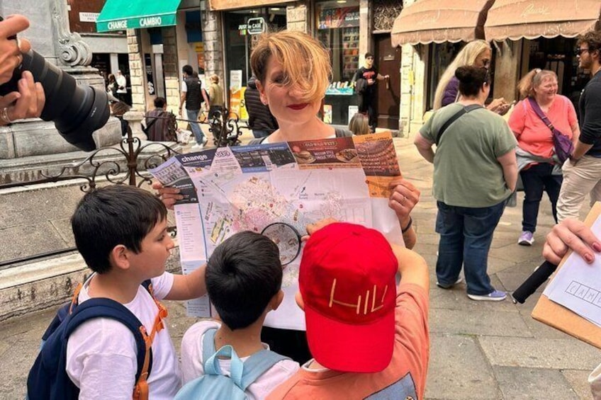 A person holding a map and a brochure, with a crowd in the background. 1