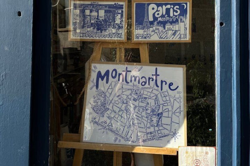 A window display with a map of Montmartre and a Paris sign. 3