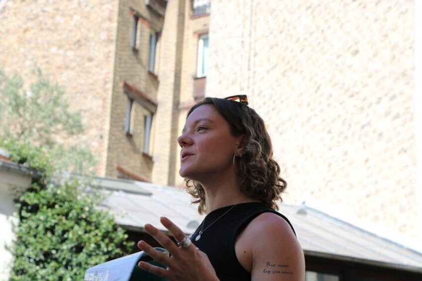 A person standing outdoors with a building in the background. 1