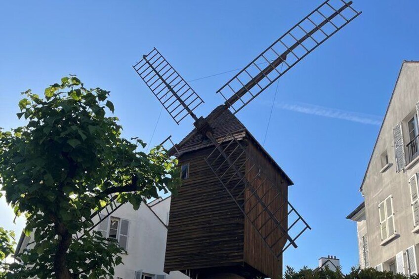 A traditional wooden windmill with multiple sails against a clear sky. 4