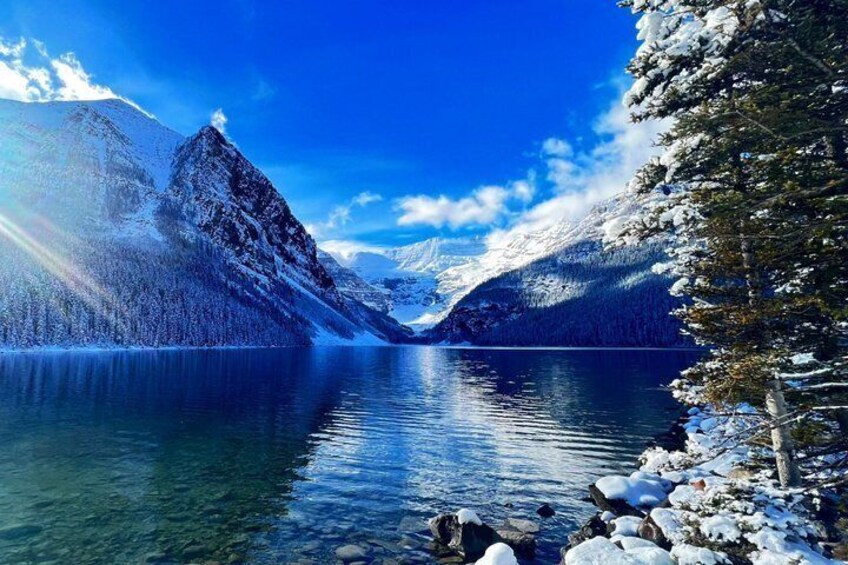 A snow-covered mountain range, a calm lake, and a clear blue sky. 3
