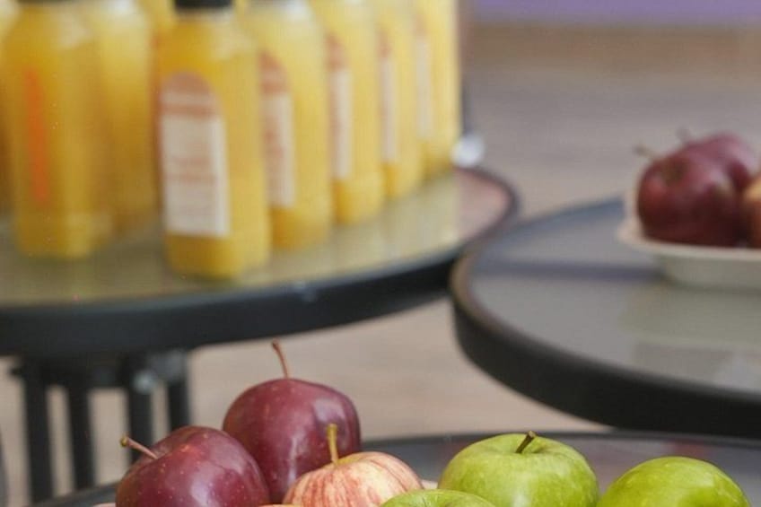 A table with apples and bottles of juice. 3