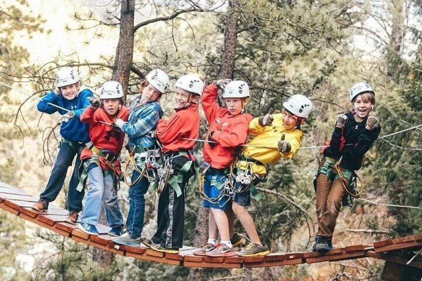 A group of people on a zip line in a forested area. 2