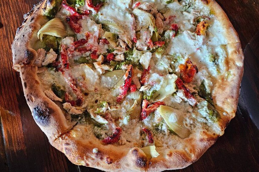 A pizza with various toppings on a wooden table. 1