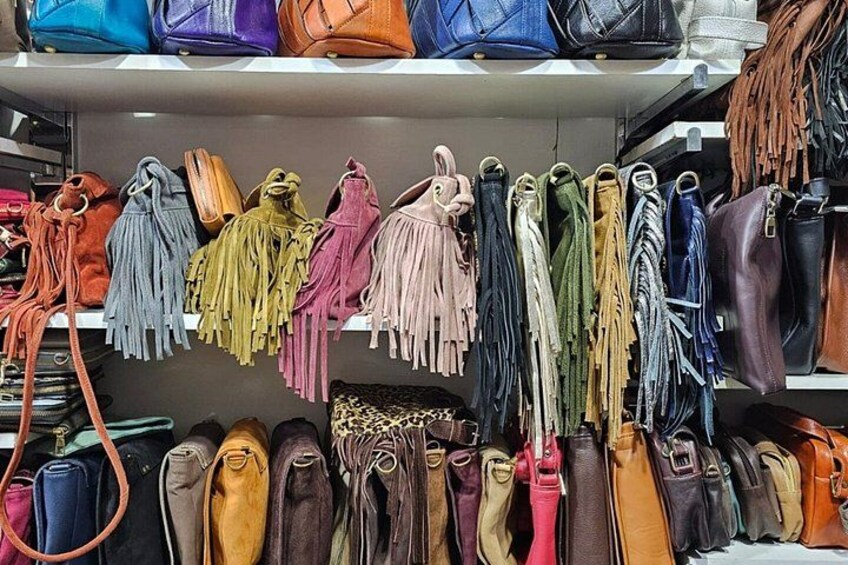 Forskellige håndtasker hænger på hylder i en butik. 3