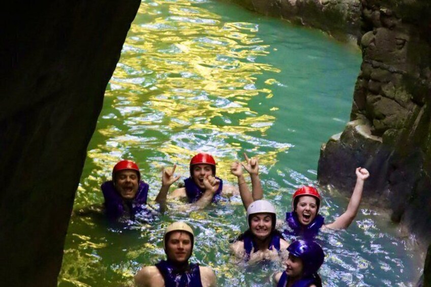 A group of people in a river wearing life jackets and helmets. 5