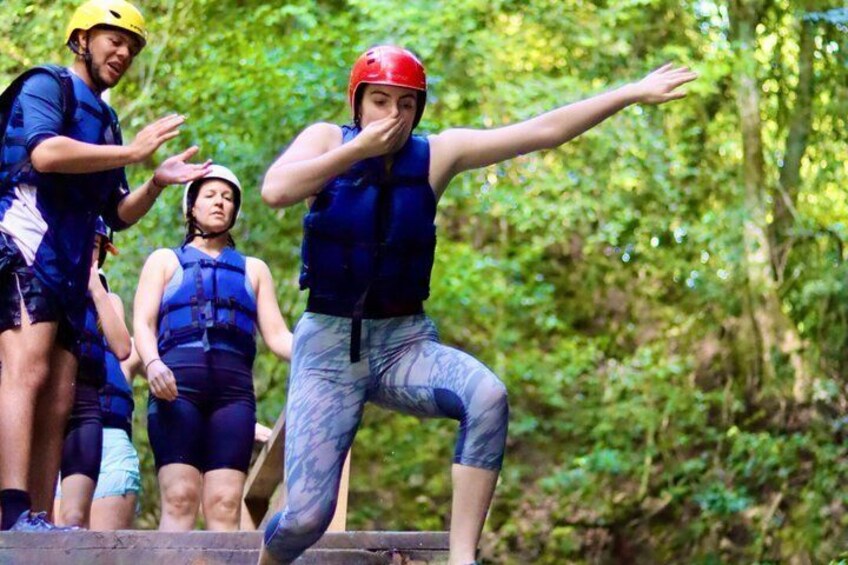 A group of people in outdoor gear, possibly on a hike or adventure trip, in a forested area. 4