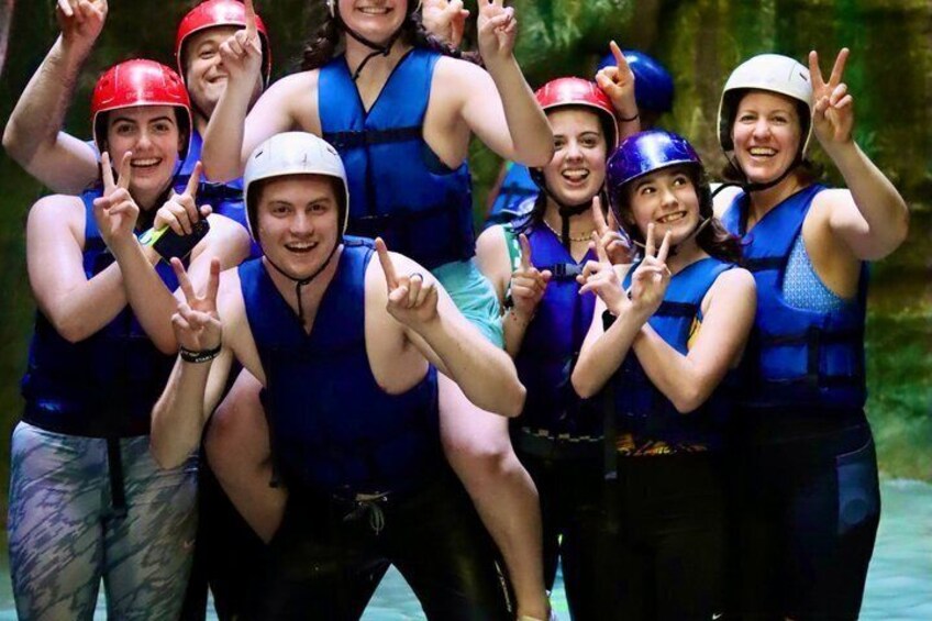 A group of people wearing life jackets and helmets, posing for a photo. 2
