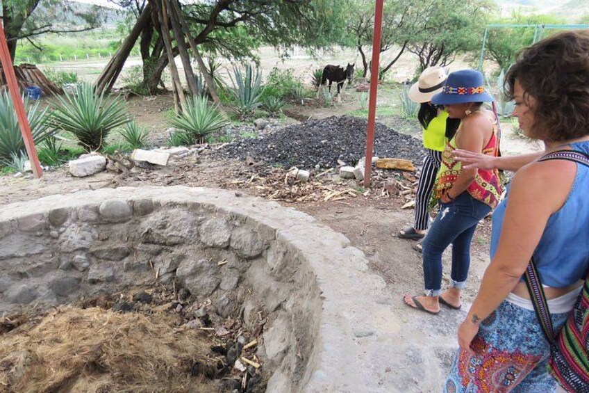 A stone well, a tree, and a cow in a rural setting. 4