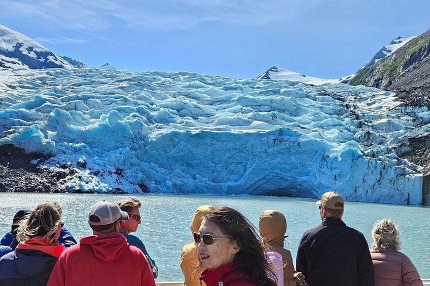 A glacier with people observing it. 3