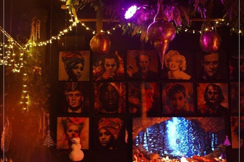 A wall with framed portraits, string lights, and a decorative pumpkin. 3