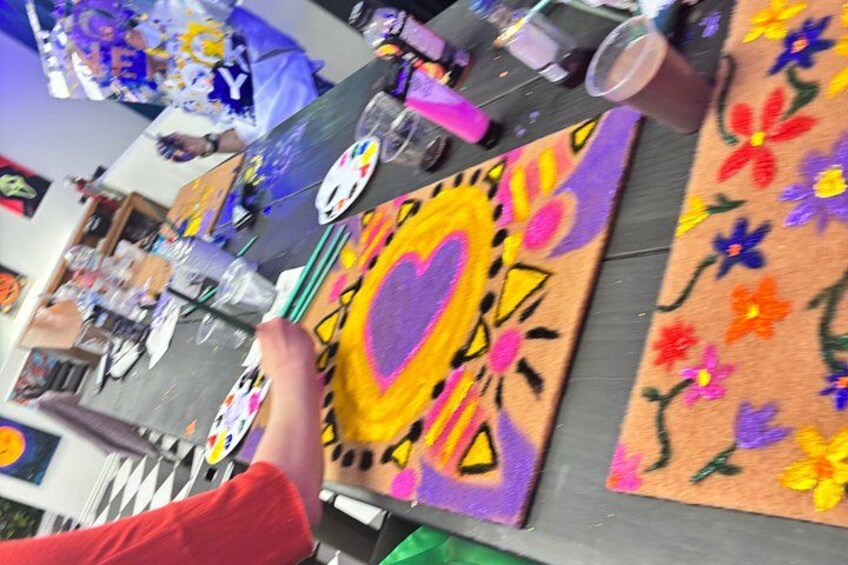 A table with colorful rugs and a heart-shaped rug in the center. 2