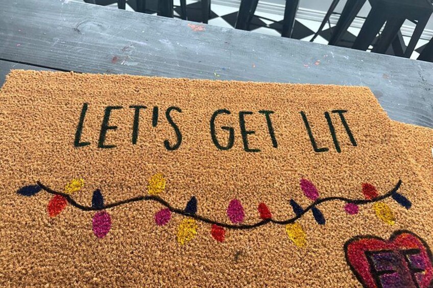 A doormat with the text 'LET'S GET LIT' and colorful decorations. 5