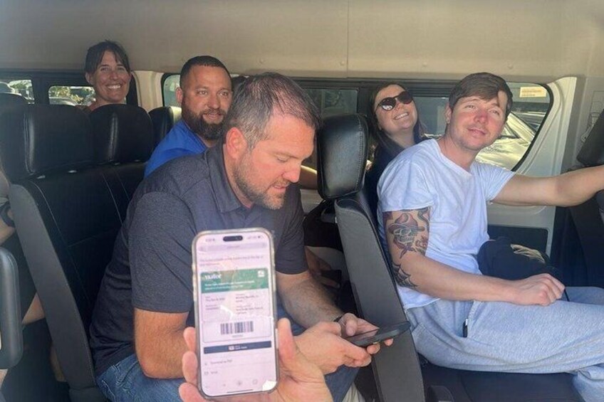 A group of people in a vehicle with a person holding a smartphone. 3