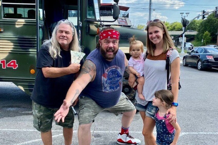 A family of four in front of a green bus with the number 14. 4