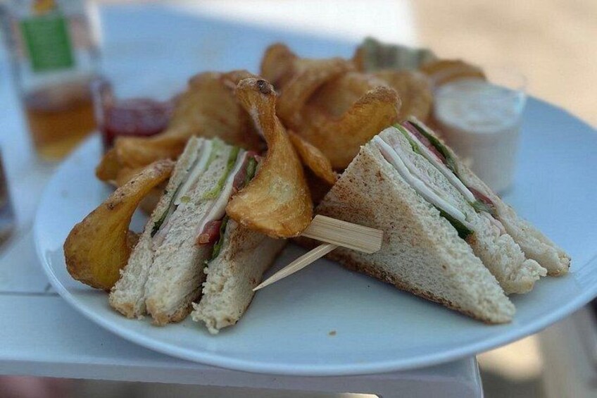 A plate with a sandwich, chips, and a drink. 3