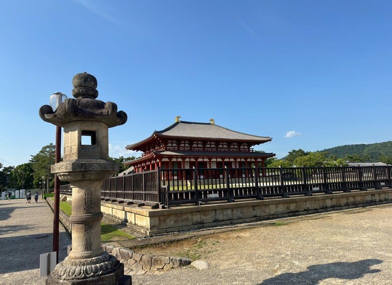 A traditional Japanese building with a tiled roof, surrounded by a gravel path and a stone lantern. 2