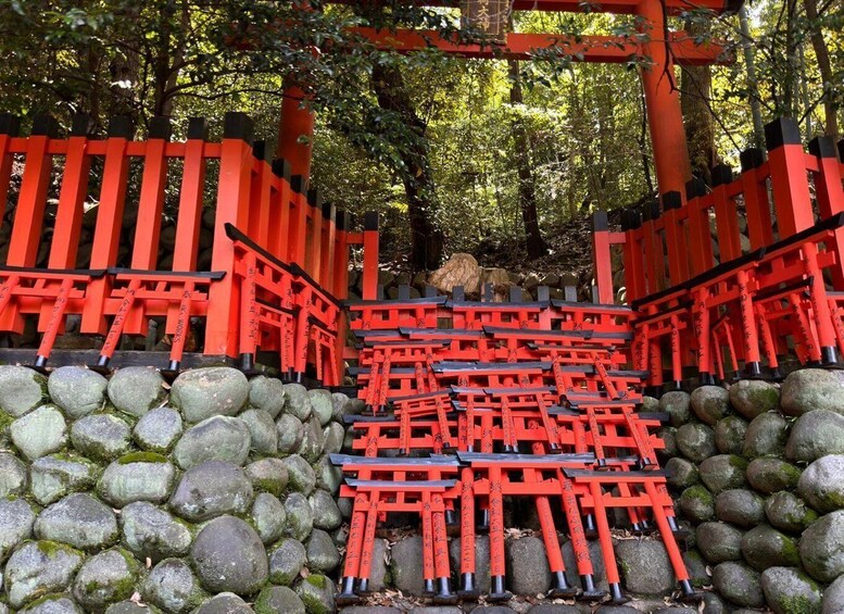 A traditional Japanese torii gate pathway leading through a forest. 4