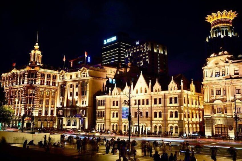 A historic building complex with ornate architecture, a large open square, and modern high-rise buildings in the background. 4