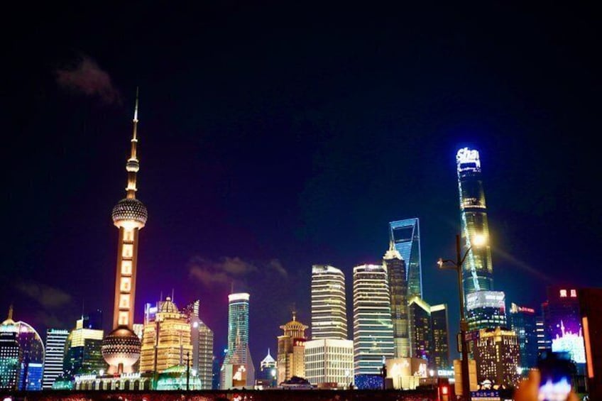 A night cityscape with illuminated skyscrapers and a prominent tower. 3