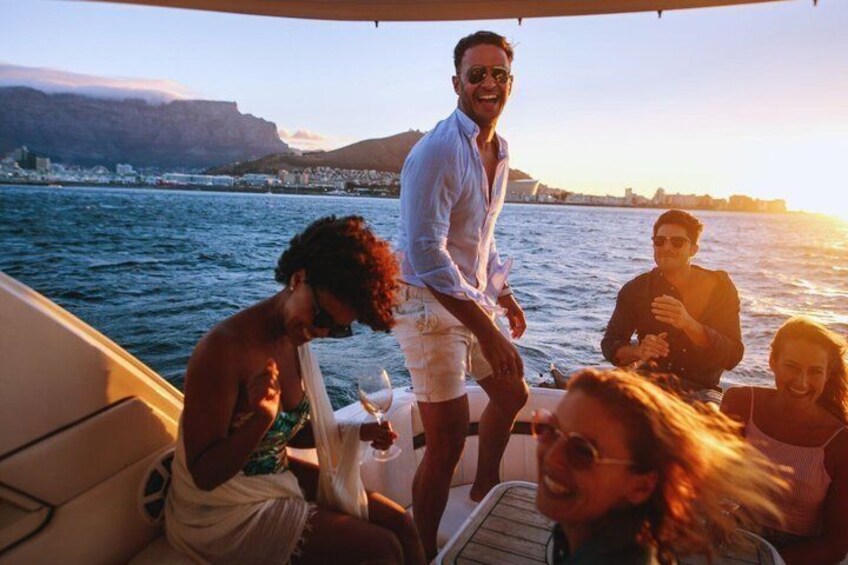 A group of people on a boat with a coastal cityscape in the background. 4
