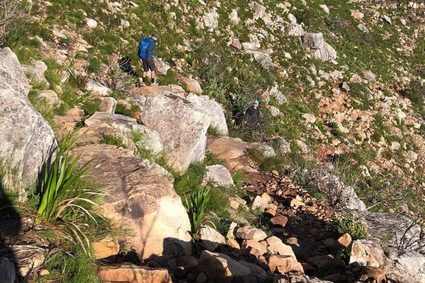 A rocky terrain with large boulders and sparse vegetation. 2