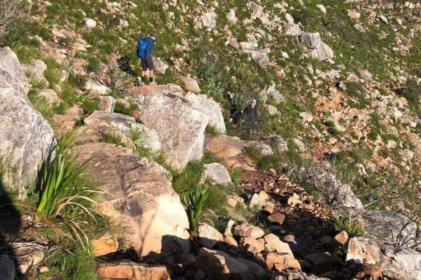 A rocky terrain with large boulders and sparse vegetation. 2
