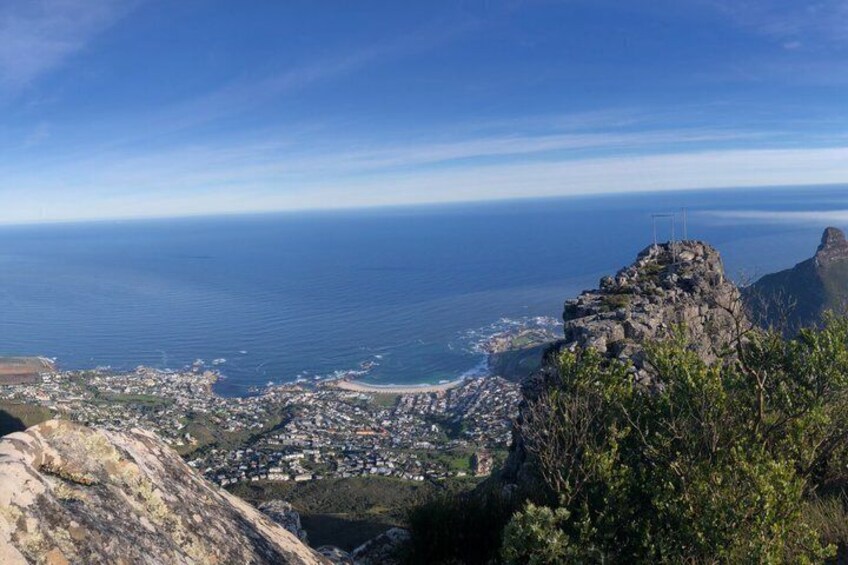 A coastal cityscape with a prominent rocky outcrop and a view of the ocean. 3
