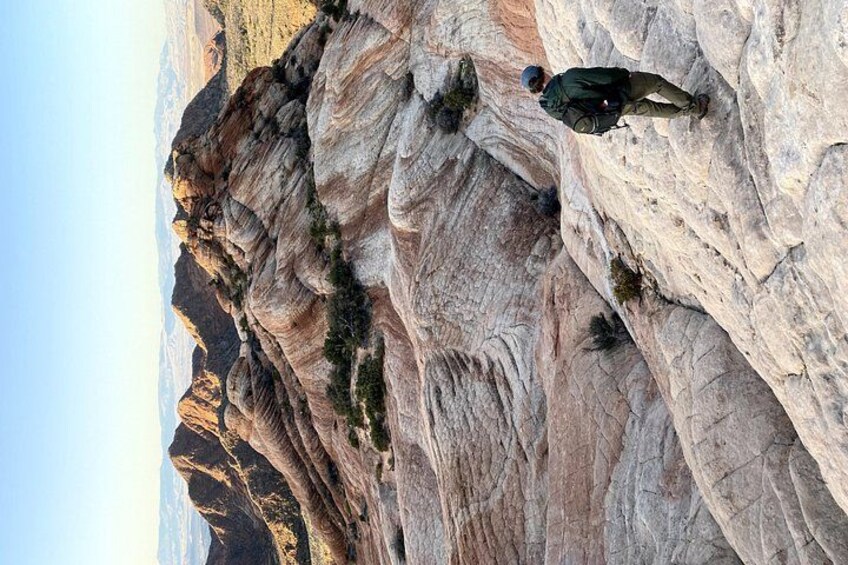 A person rock climbing on a steep, rocky cliff. 3