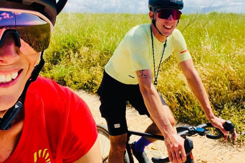 Two people on bicycles in a grassy field. 3