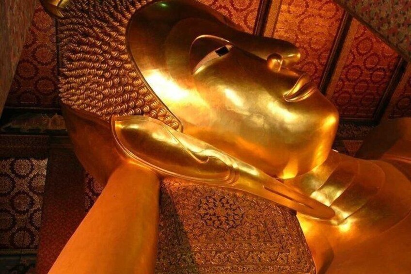A golden sculpture of a hand in a room with patterned carpet and walls. 1