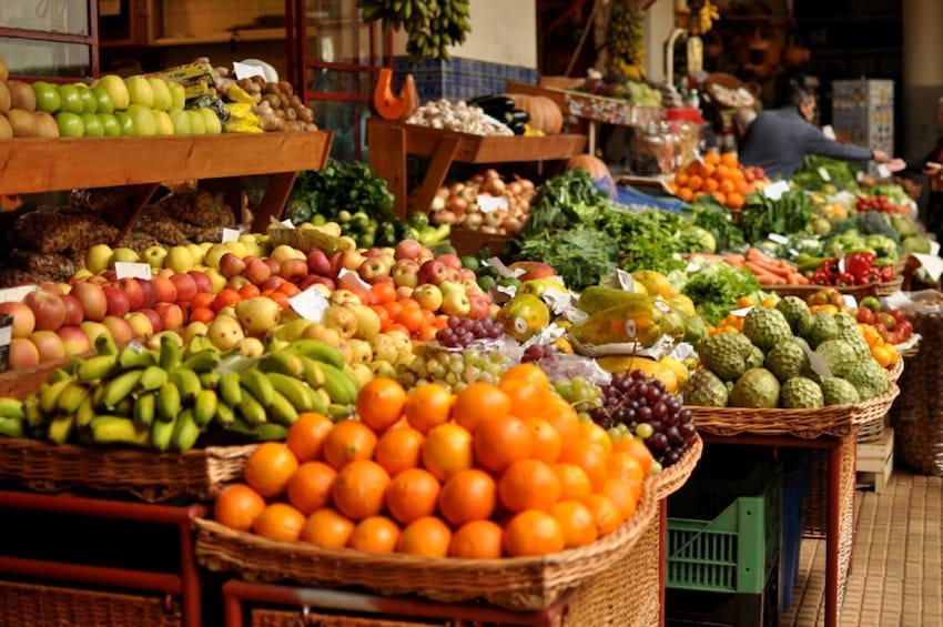 A fruit market with various fruits displayed in baskets. 4