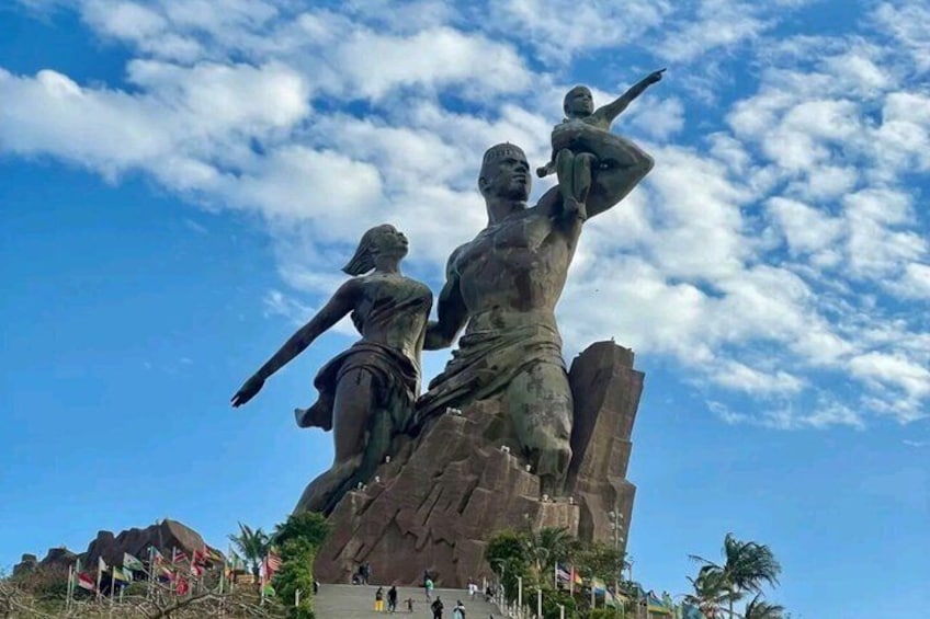 A large statue of a man and a woman with a child, set against a clear sky. 1