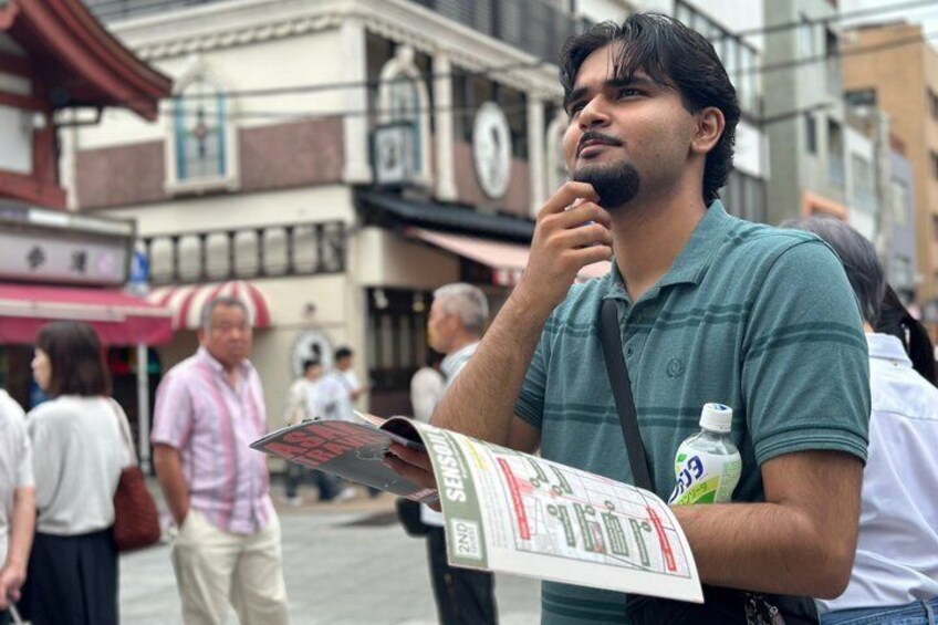 A man holding a newspaper in an urban setting with buildings and pedestrians in the background. 4
