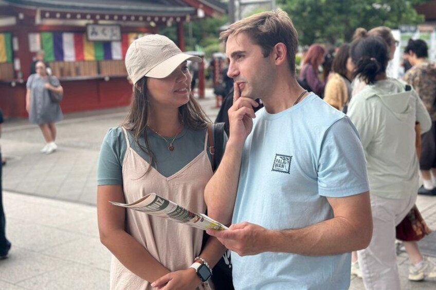 Two people standing outdoors, one holding a map. 5